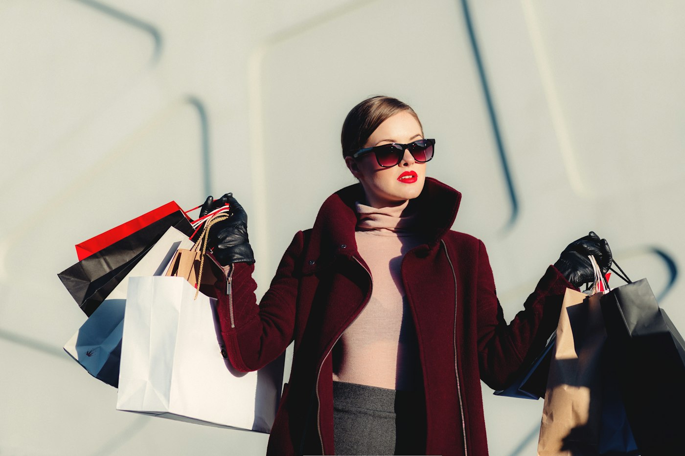 Femme souriante tenant plusieurs sacs de shopping