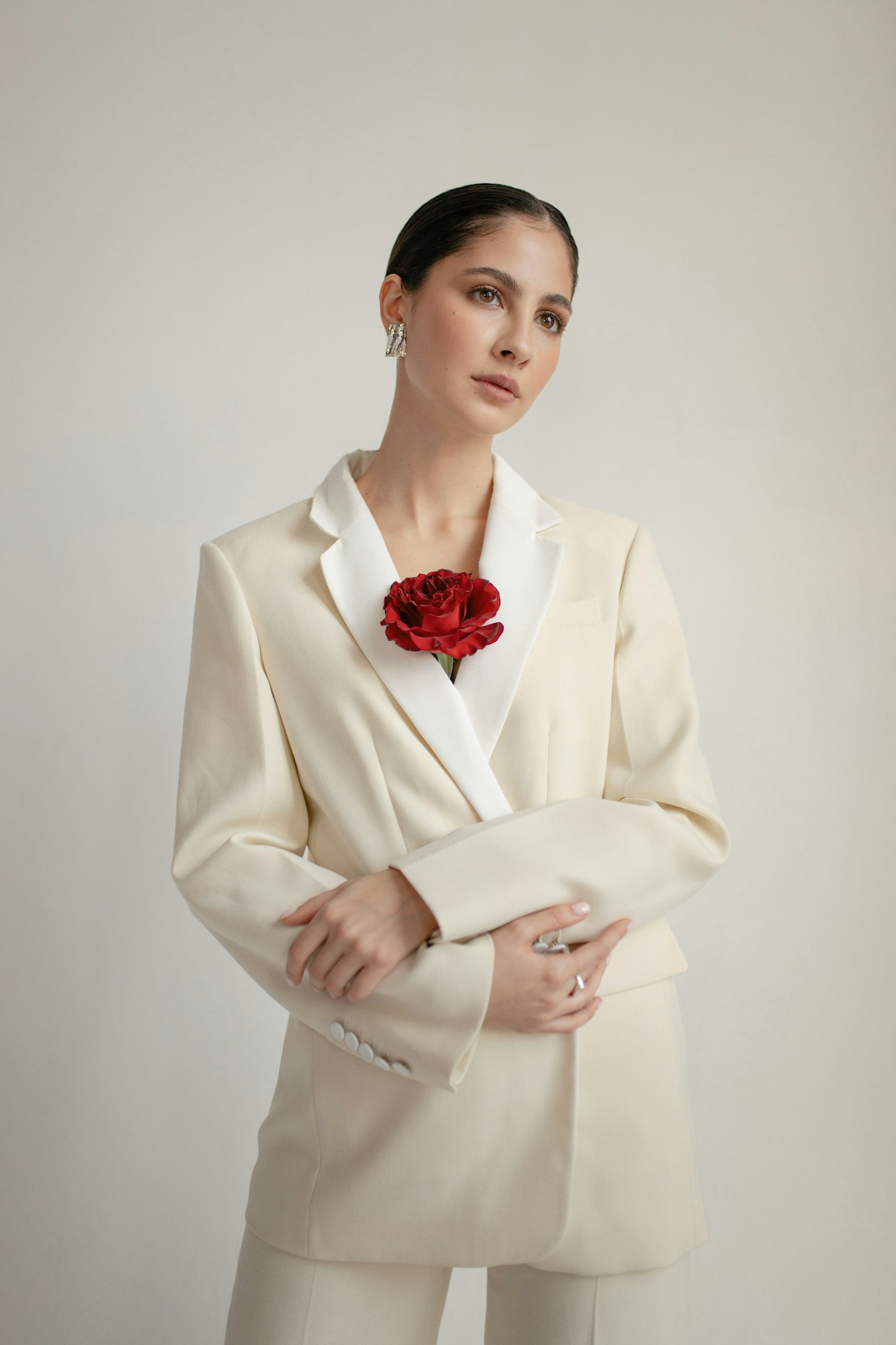 Femme en tailleur clair assise sur un canapé Chesterfield en cuir marron